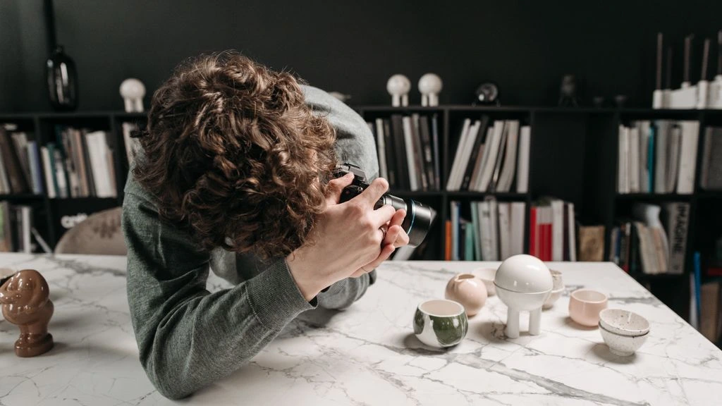 A represented artist working quietly inside her studio at dawn.